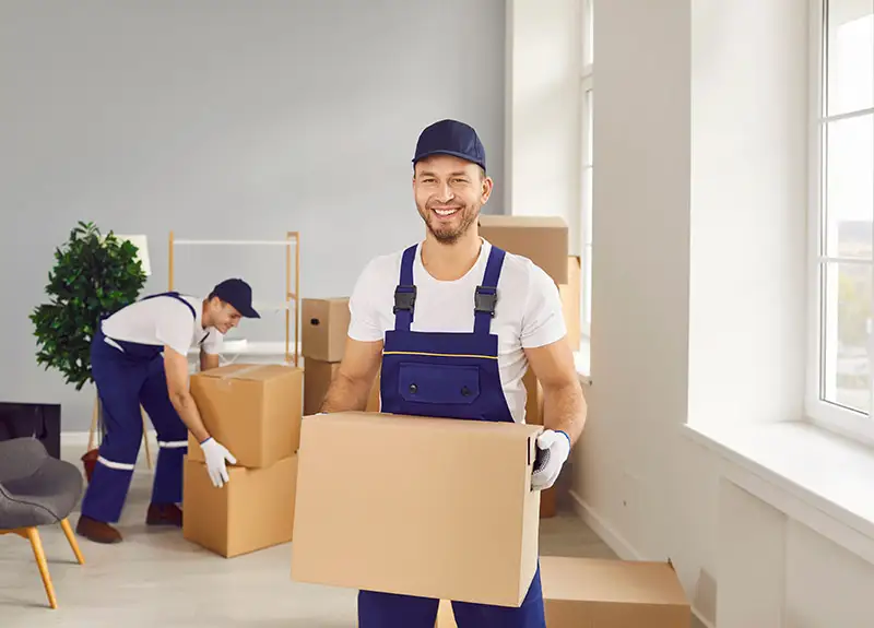 Umzugshelfer trägt einen Karton