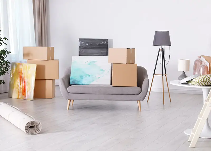Möbelstücke und Kartons in einer Wohnung warten auf Abtransport