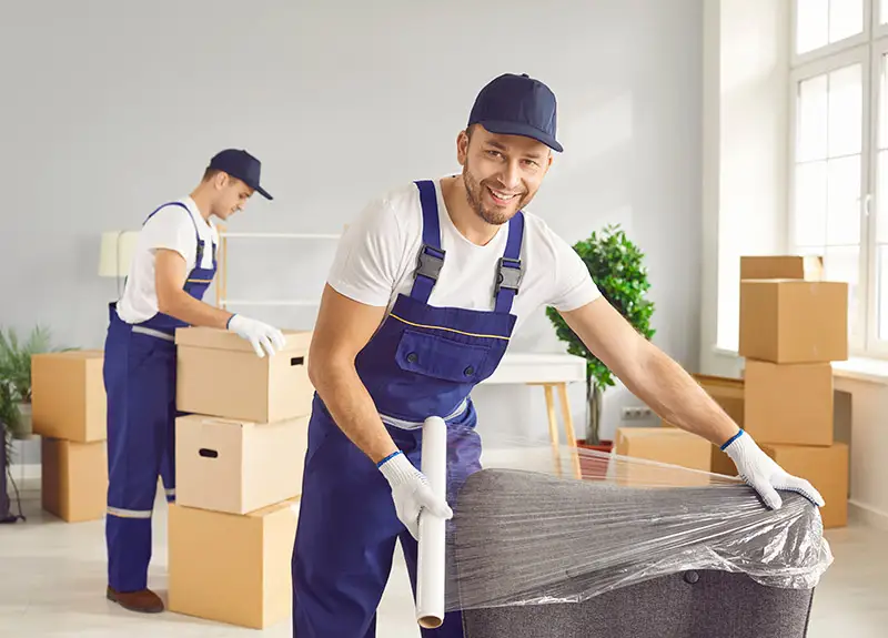 Profi-Umzugshelfer beim Verpacken von Möbeln