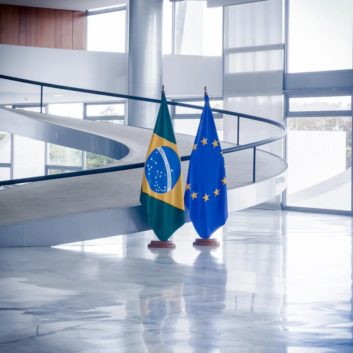 Brasilianische und EU-Flagge in modernem Gebäude.