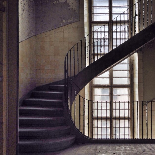 Geschwungene Wendeltreppe in einem verlassenen, verfallenen Gebäude.